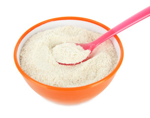 Powdered milk in bowl and spoon for baby isolated on white