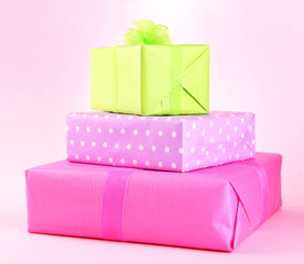 Bright gifts with bows on pink background