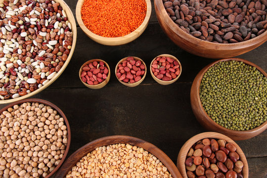 Different kinds of beans in bowls on  table close-up