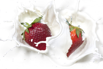 Strawberries dropped into cream.