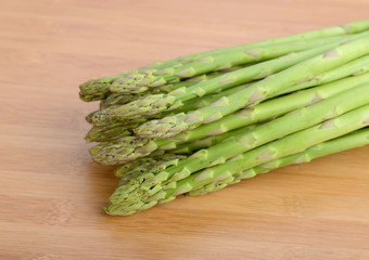 fresh green asparagus sprouts laying on bamboo background