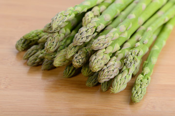 fresh green asparagus sprouts laying on bamboo background