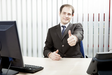 Confident businessman giving a thumbs up