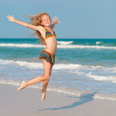 Fototapeta na wymiar flying jump beach girl on blue sea shore in summer vacation