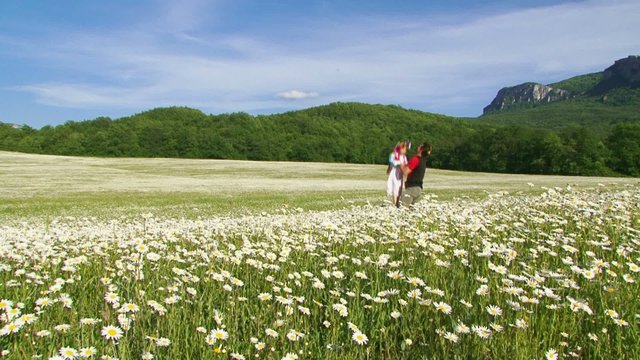 Father and daughter on a walk in a blooming field