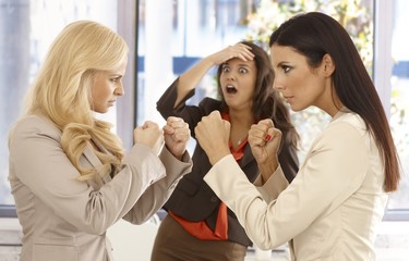 Determined businesswomen fighting at workplace