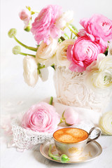 Silver cup of coffee with ranunculus