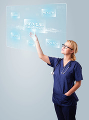 Young nurse pressing modern medical type of buttons