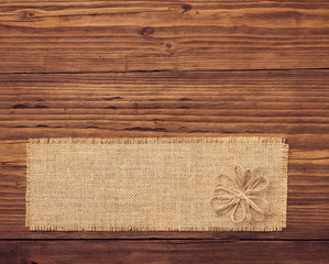Sackcloth tag over brown wooden board background