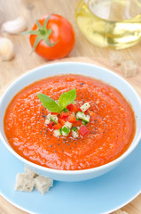 cold tomato soup gazpacho with basil in a bowl, top view