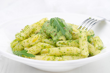 pasta penne with sauce of arugula and peas on a plate