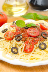 spaghetti with tomato sauce, cherry tomatoes and olives vertical