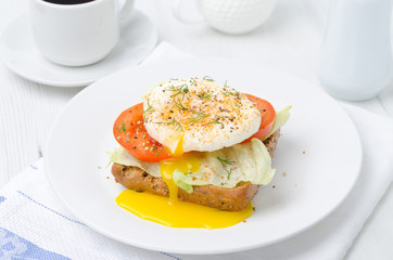 toast with tomato, lettuce and poached egg for breakfast