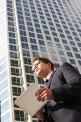 Businessman Working On Tablet Computer Outside Office