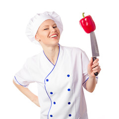 Happy female chef with red pepper on a knife preparing to cook