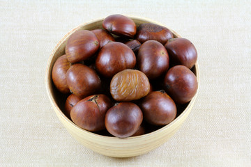 A Bowl of Roasted Sweet Chestnuts on fabric background