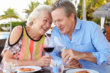 Senior Couple Enjoying Meal In Outdoor Restaurant