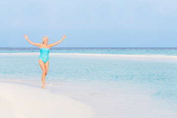 Fototapeta na wymiar Senior Woman Splashing In Beautiful Tropical Sea