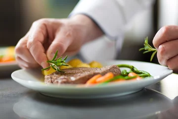 Fotobehang Gerechten Chef-kokhanden die een schotel in restaurantkeuken verfraaien