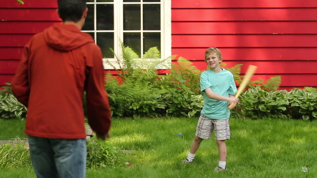 Boy Playing Baseball In The Backyard