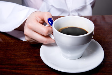 Woman holding cup of coffee on background