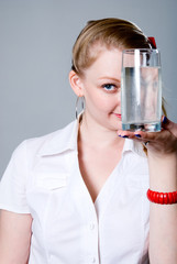 Portrait of a pretty young woman holding a glass of water