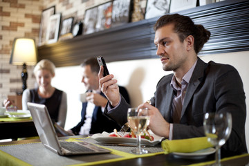The businessman using the laptop and mobile in cafe.