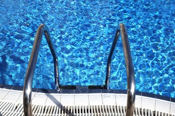 Obraz na płótnie Canvas jasne, niebieskie wody w basen z drabinką
