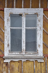 Damaged house with wooden window
