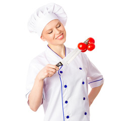 Happy woman cook looking at red tomatoes hanging on a knife