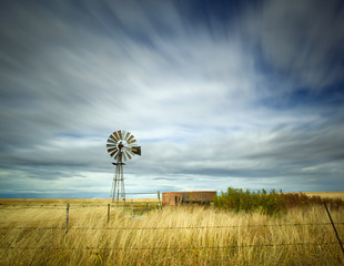 long exposure image with windmill and streaky clouds