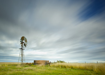 long exposure image with windmill and streaky clouds