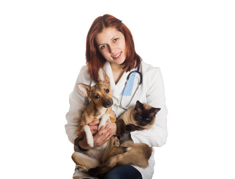 vet in medical uniform holding a cat and a dog on a white backgr