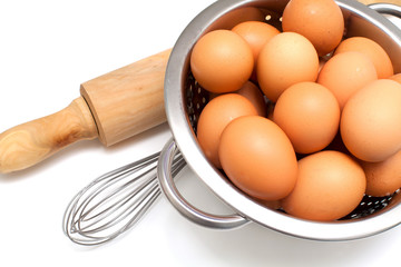 metal colander with eggs over white