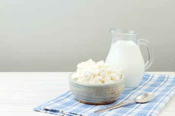 Cottage cheese and milk on white wooden table