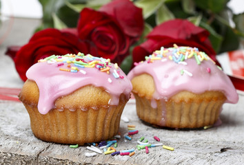 Muffins with pink icing and colorful sprinkles