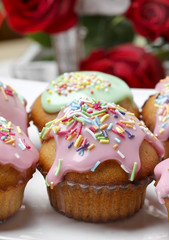 Muffins with pink icing and colorful sprinkles