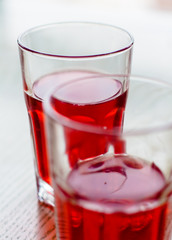Two red cranberry fruit drinks in glass