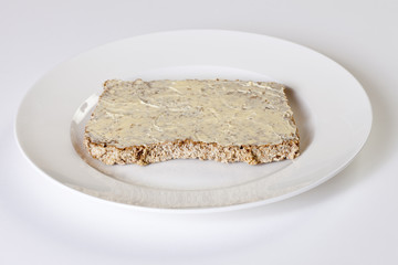 Teller mit Brotscheibe mit Butter