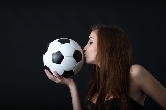 sexy woman in lingerie kissing a classic soccer ball