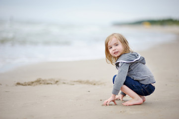 Adorable girl playing on the beach