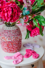 still life with newborn socks and vase with flowers
