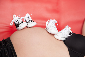 Pregnant belly with two pairs of shoes - 51328998