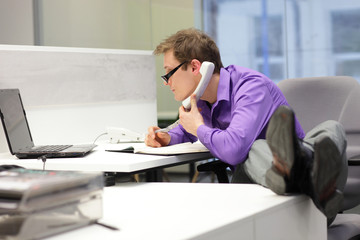 businessman on phone looking at screen - bad sitting posture - obrazy, fototapety, plakaty