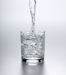 Water flowing into full glass