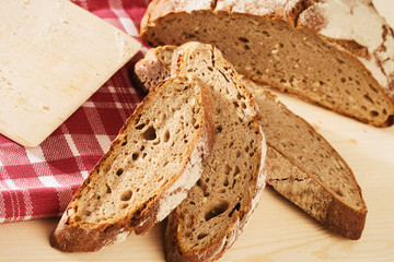 geschnittenes rustikales brot mit schneidebrett und geschirrtuch
