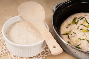 Sourdough in  a white bowl with focaccia bread and doily