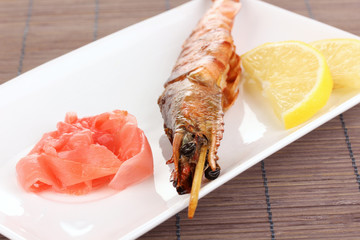 king prawn skewers on plate with ginger and lemon