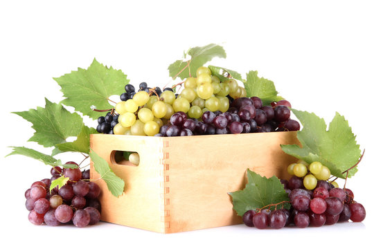 assortment of ripe sweet grapes in wooden crate, isolated