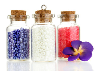 Little bottles full with colorful beads isolated on white